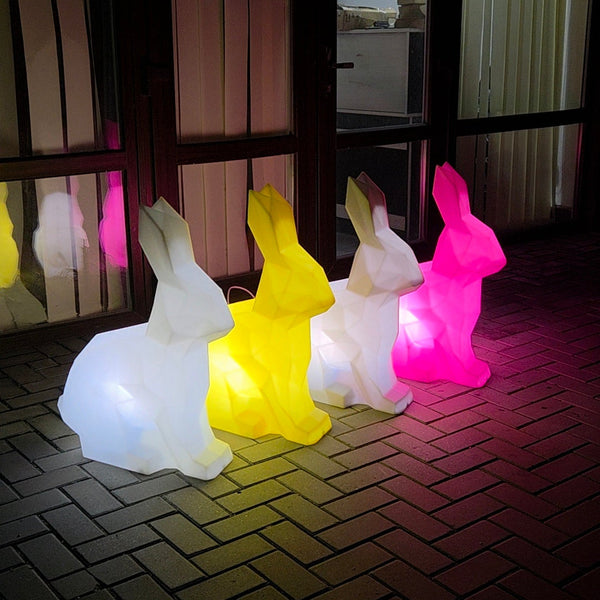 Colorful rabbit-shaped lights on a tiled floor with a reflective surface in the background.