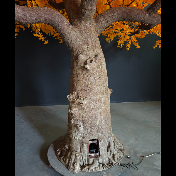 Decorative tree sculpture with a base on a gray surface