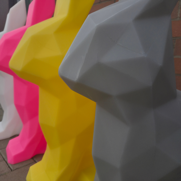 Geometric animal sculptures in various colors on a tiled floor.