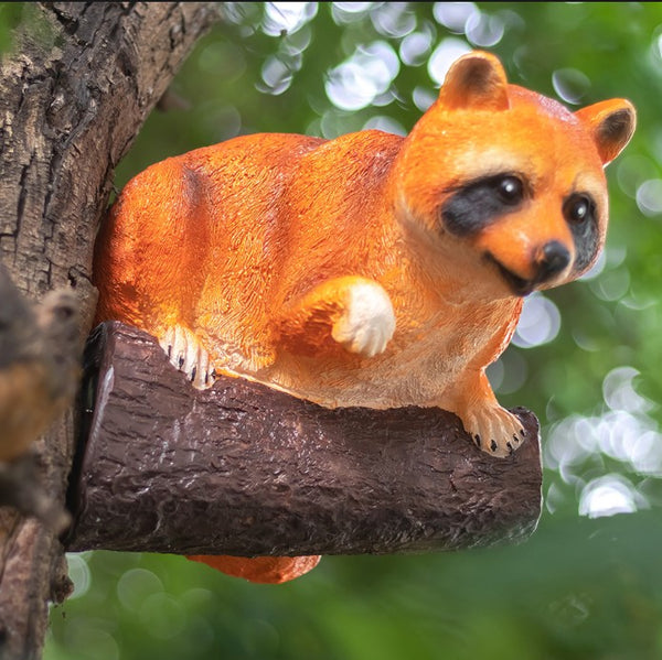 Solar powered raccoon garden statue glowing at night with warm white LED light