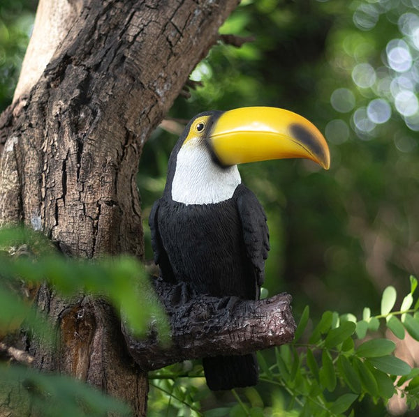 Toucan perched on a tree branch with a blurred green background