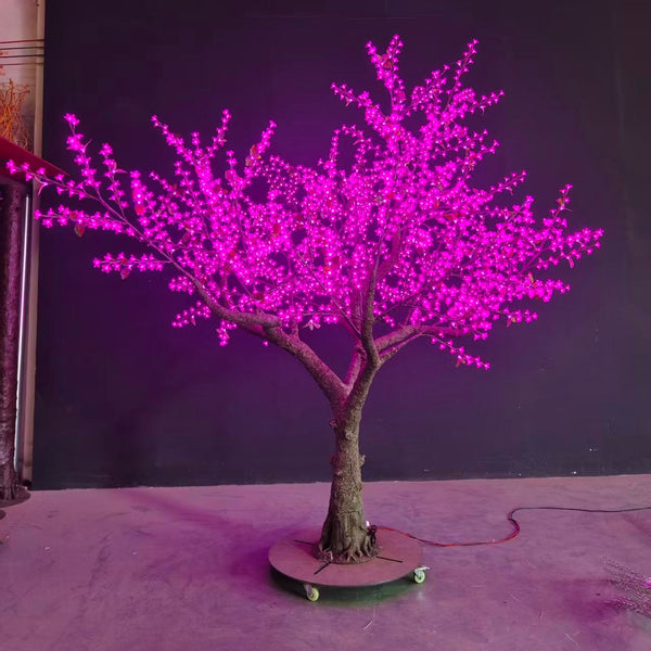Decorative LED tree with pink lights on a purple background
