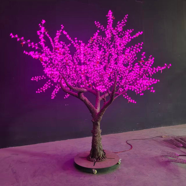 Decorative LED tree with pink lights on a dark background