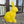 Yellow geometric rabbit sculpture on a paved surface with glass doors in the background