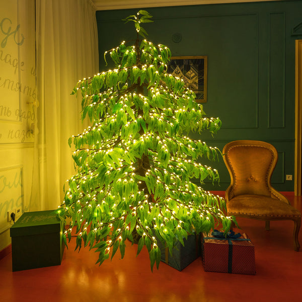 LED Christmas tree with warm white lights and green leaves for indoor holiday decoration.