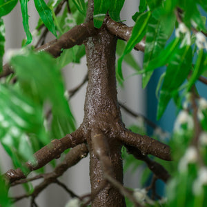 Close-up of a realistic LED tree trunk with green leaves for indoor and outdoor decoration.