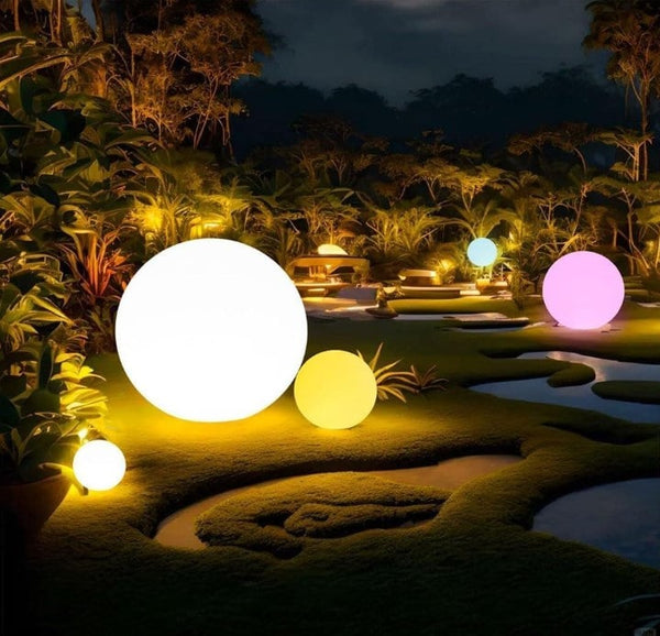 Decorative spherical lights in various colors on a garden path at night.