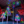 A set of illuminated LED decorative trees with colorful starburst branches, displayed in a large indoor event space with a reflective blue floor and high ceiling.
