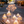 A set of illuminated decorative trees with white stems and glowing warm yellow starburst canopies, displayed on a city sidewalk along a street at night.