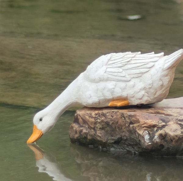 White duck sculpture on a rock in water