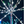 White and green LED branch-style string lights arranged on a central pole against a dark night sky.