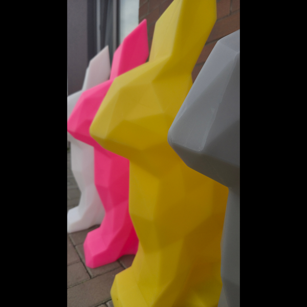 Colorful geometric chairs in yellow, pink, and white on a tiled floor.