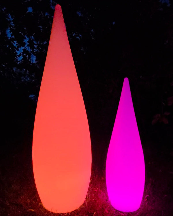 Two colorful, illuminated outdoor lights on a dark background